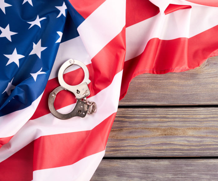 USA flag and handcuffs, top view.