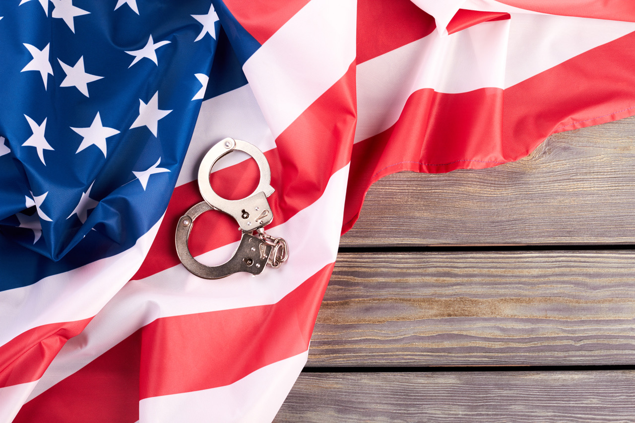 USA flag and handcuffs, top view.